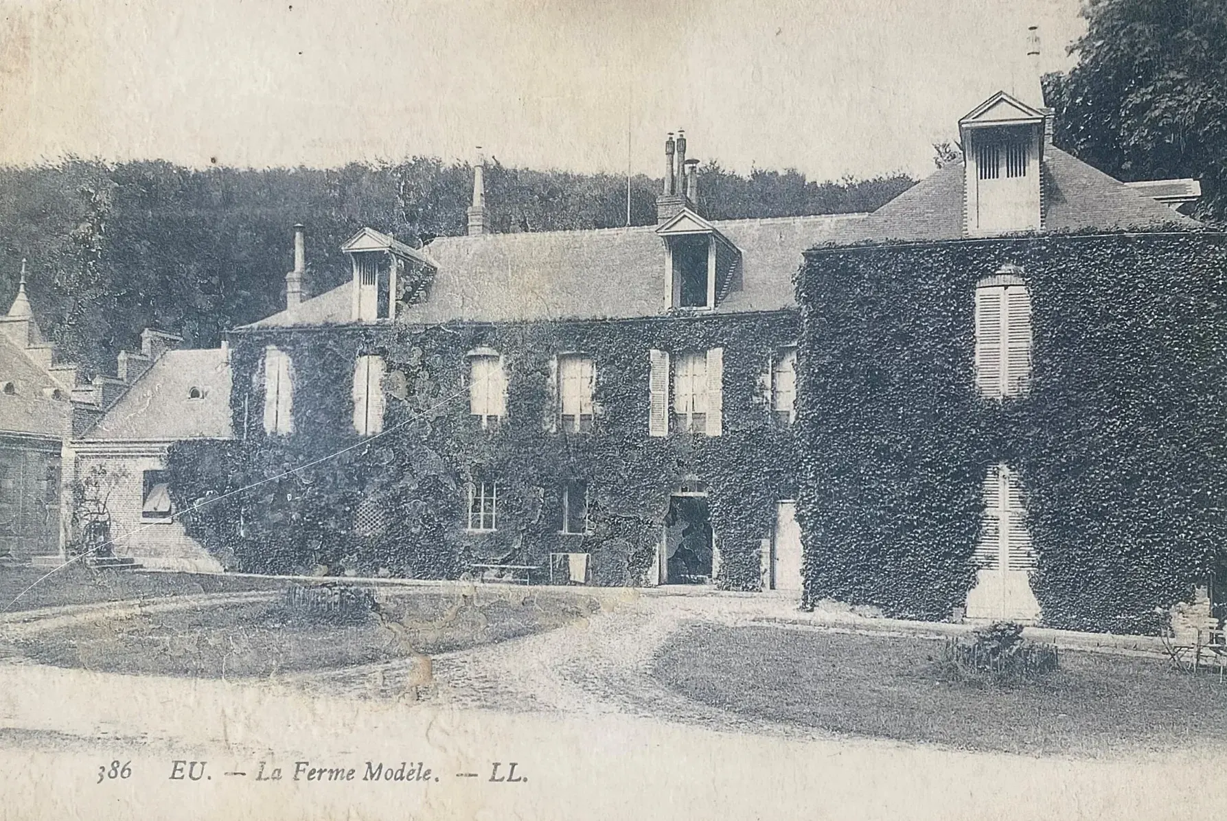 Carte postale ancienne de La Ferme Modèle, la façade couverte de lierre