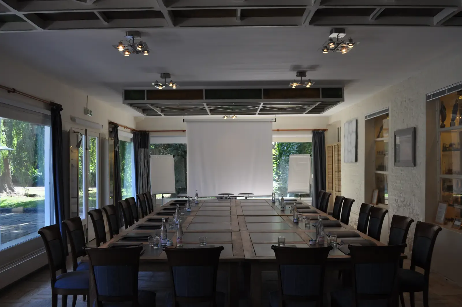 Salle de séminaire installée autour d’une grande table en bois